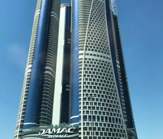 Une vue des Damac Towers Paramount, avec des gratte-ciel modernes au design élégant, sous un ciel bleu clair.