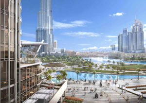 Un paysage urbain moderne avec une place animée avec des gens, entourée de grands gratte-ciel, un ciel bleu clair et des résidences emblématiques de Grande au bord d'un plan d'eau calme.