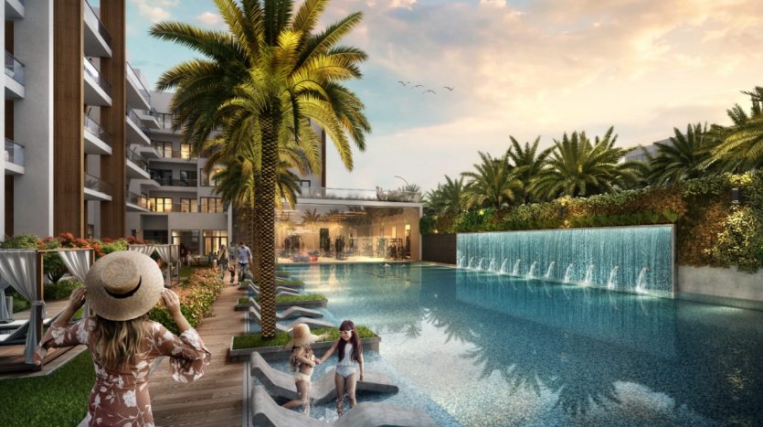 Un espace piscine luxueux avec des gens qui se détendent et des enfants dans un canoë, entouré de palmiers luxuriants et de bâtiments du Panthéon Elysée.