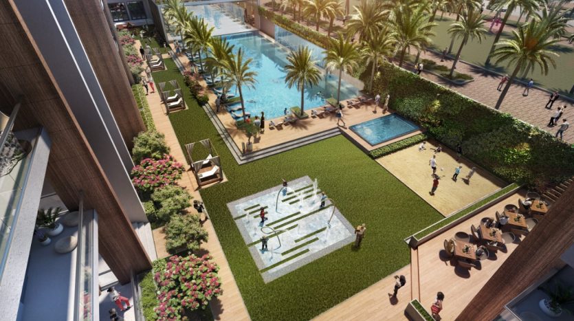 Vue aérienne d&#039;un espace de loisirs extérieur animé comprenant une piscine, un terrain de volley-ball et une terrasse pour bronzer, entouré de palmiers luxuriants et des bâtiments modernes du Panthéon Elysée.