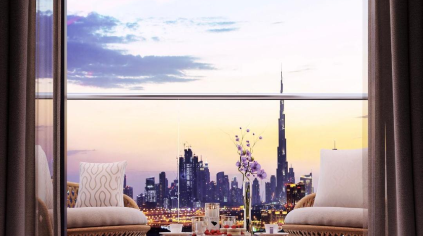 Un balcon luxueux avec vue sur la crique de Dubaï au coucher du soleil, doté de confortables chaises en osier, d&#039;une table dressée avec des collations et de grandes portes vitrées.