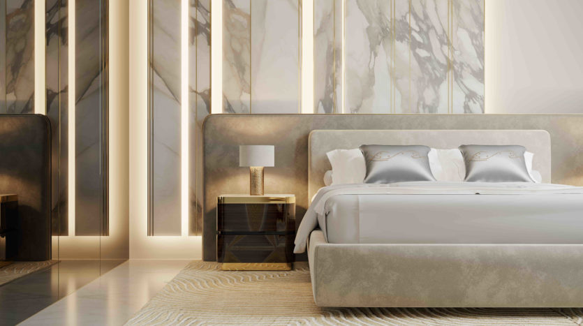 Une chambre luxueuse avec un grand lit recouvert de draps blancs, flanqué de tables de nuit et de lampes, sur fond de murs en marbre et de panneaux lumineux verticaux à l&#039;Elie Saab Ema