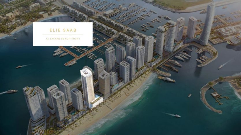 Vue aérienne d&#039;un développement urbain côtier intitulé &quot;Elie Saab at Emaar Beachfront&quot; comprenant de nombreux immeubles de grande hauteur et marinas, entourés d&#039;eau.