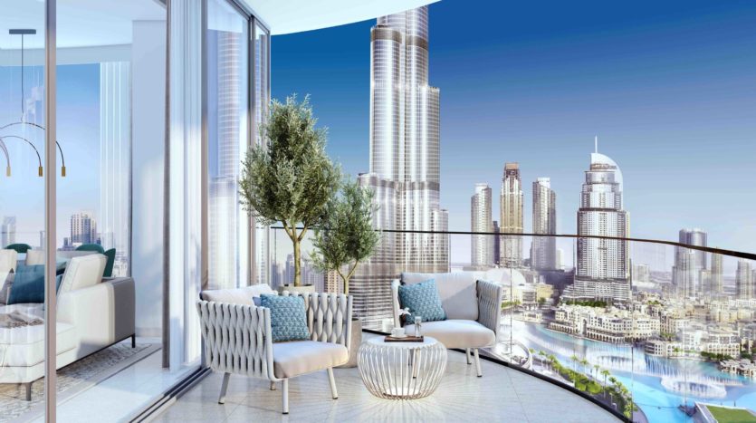 Luxueux balcon de grande hauteur doté d&#039;un mobilier moderne dans des résidences de marque Grande, surplombant un paysage urbain avec d&#039;imposants gratte-ciel et une rivière sous un ciel bleu clair.