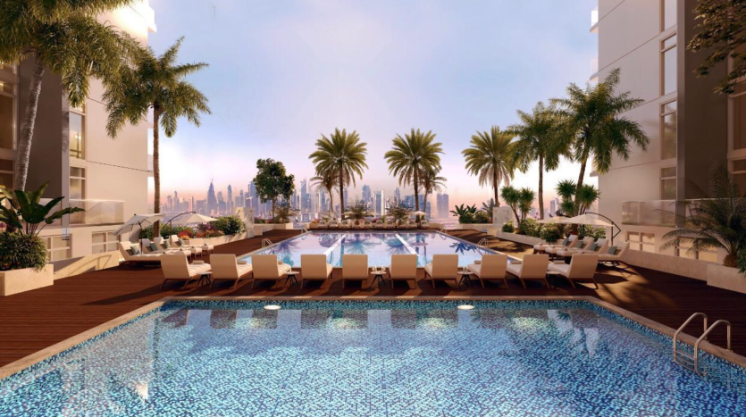 Piscine luxueuse sur le toit entourée de chaises longues et de palmiers avec Creek Vistas Dubai en arrière-plan au coucher du soleil.