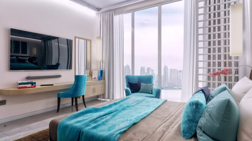 Chambre moderne avec un grand lit recouvert de lin turquoise, des chaises assorties, une télévision murale, sept œuvres d&#039;art sur le thème des palmiers, de grandes fenêtres avec vue sur le paysage urbain et un éclairage ambiant.