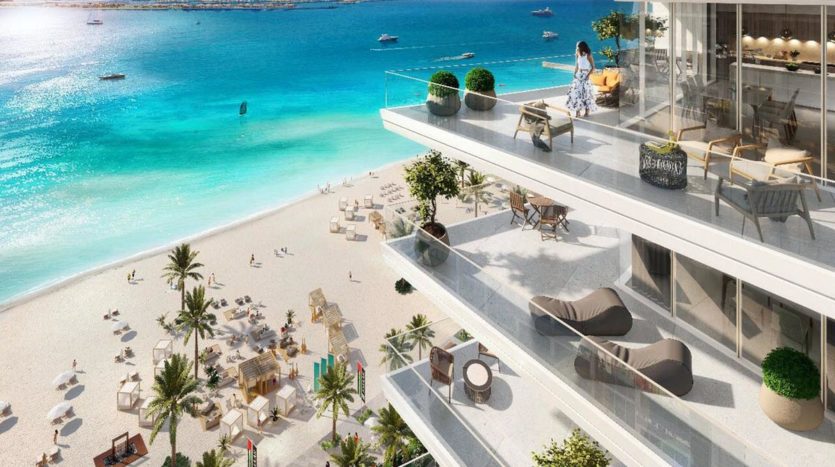 Un luxueux restaurant en bord de mer conçu par Elie Saab avec une terrasse extérieure surplombant une mer turquoise, une plage de sable fin et des amateurs de plage, offrant une expérience culinaire pittoresque.