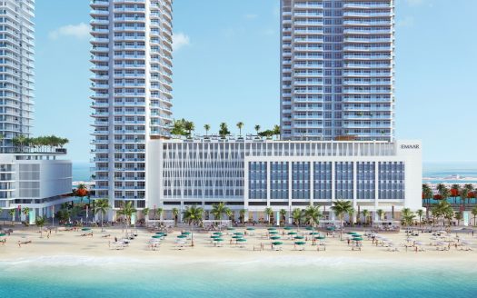 Un complexe luxueux avec vue sur la marina avec trois grands bâtiments, des palmiers, une plage de sable bondée avec des parasols colorés et un ciel bleu clair.