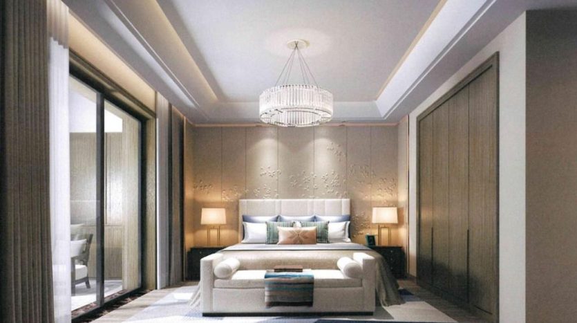 Chambre élégante dans la tour Nobles avec un grand lit, une tête de lit élégante et une literie moelleuse. Un lustre est suspendu au-dessus, avec un éclairage doux et un mobilier moderne, créant une ambiance chaleureuse et luxueuse.