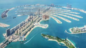 Vue aérienne du palmier Jumeirah à Dubaï, montrant son archipel artificiel distinctif en forme de palmier bordé de villas de luxe et de bâtiments résidentiels.