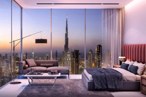 Un intérieur d&#039;appartement moderne au crépuscule avec de grandes fenêtres en verre offrant une vue panoramique sur les toits de la ville de Dubaï avec un grand gratte-ciel. La chambre comprend un canapé, un lit et une décoration élégante.