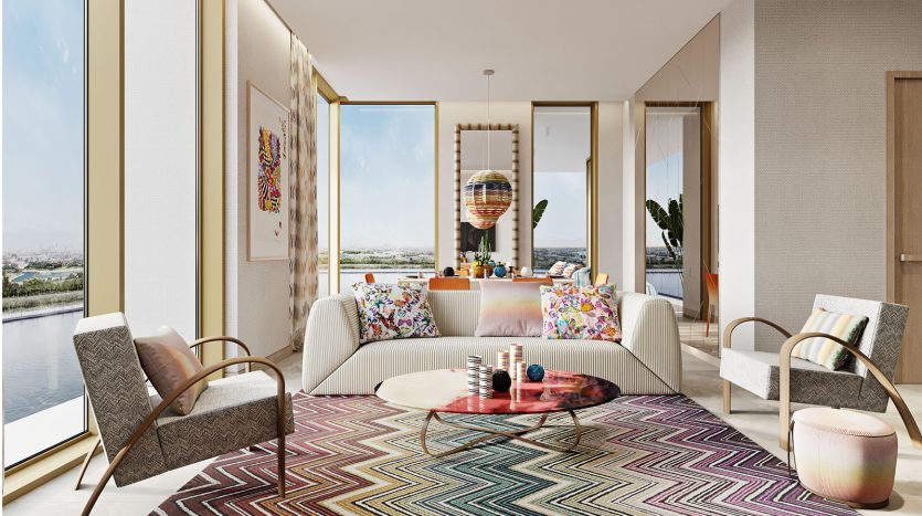 Salon moderne avec de grandes fenêtres offrant une vue panoramique, comprenant un tapis à chevrons colorés de Missoni, une table basse ronde et des chaises rembourrées à fleurs. Espace lumineux et aéré avec une lumière naturelle abondante