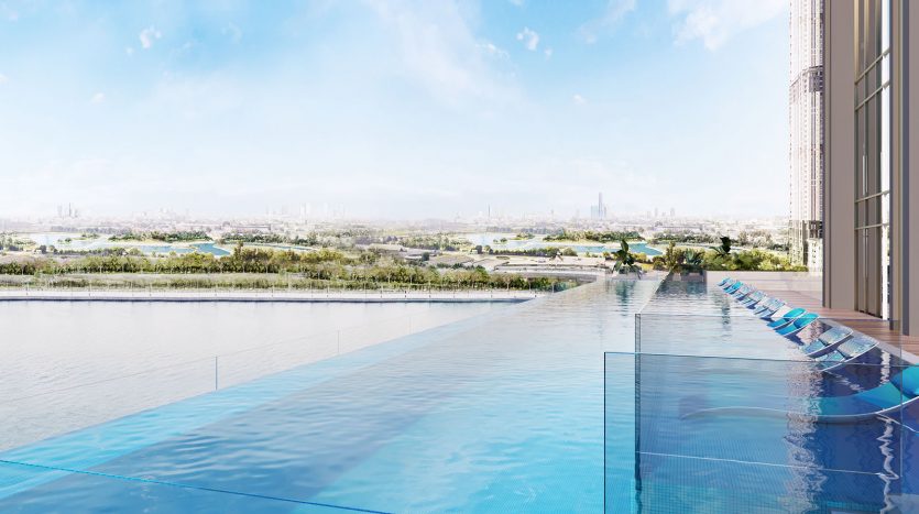 Piscine à débordement située dans un immeuble de grande hauteur, conçue comme une oasis urbaine par Missoni, avec une vue panoramique sur un paysage urbain luxuriant et une rivière, sous un ciel bleu clair.