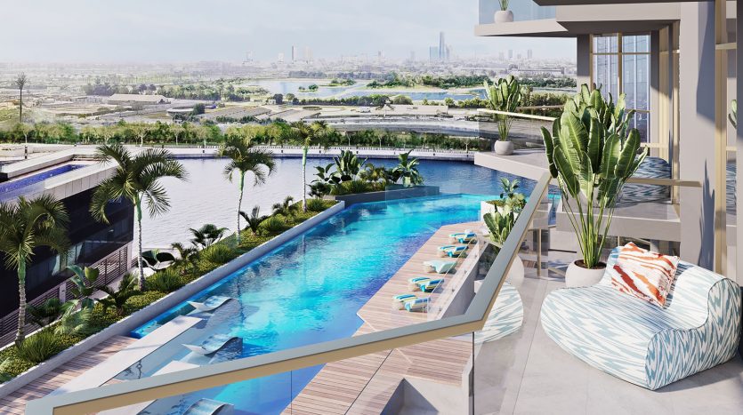 Un balcon spacieux donnant sur une luxueuse piscine à débordement entourée de palmiers, avec un paysage urbain tranquille au loin sous un ciel dégagé. Des sièges confortables et des plantes luxuriantes rehaussent l'ambiance sereine de cette oasis urbaine