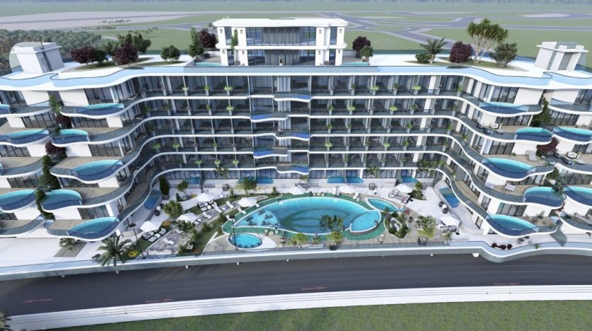 Vue aérienne d&#039;un complexe moderne à plusieurs étages avec balcons et piscines, entouré des espaces paysagers du parc Samana et à proximité d&#039;une route.