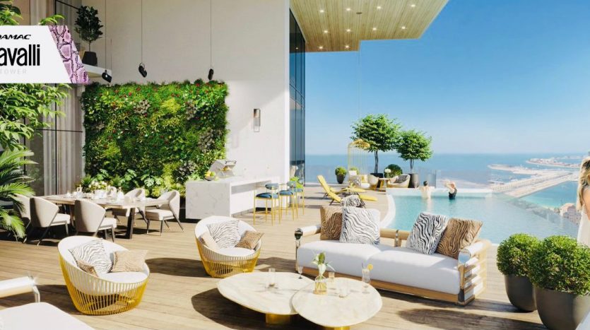 Toit-terrasse luxueux doté d&#039;un mobilier d&#039;extérieur élégant surplombant la mer, doté d&#039;une verdure luxuriante et d&#039;une femme regardant la vue. Logo de la tour Roberto Cavalli Dubaï visible.