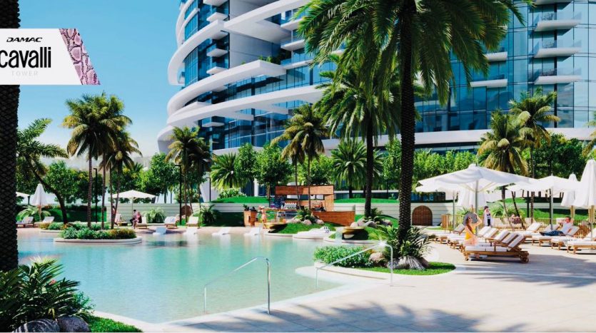 Un espace piscine extérieur extravagant à la tour Roberto Cavalli de DAMAC à Dubaï, avec des palmiers verts luxuriants, plusieurs chaises longues, des bâtiments modernes et un plan d&#039;eau serein.