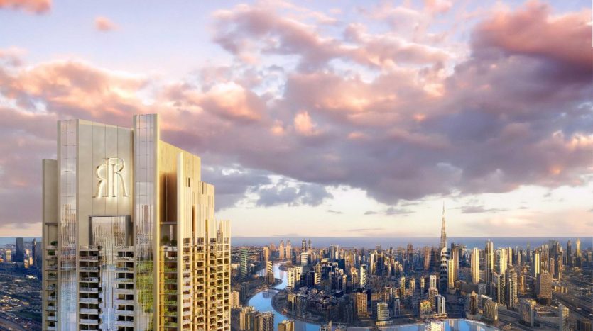 Une ligne d&#039;horizon futuriste au coucher du soleil avec un gratte-ciel proéminent au premier plan orné d&#039;un grand logo « r », surplombant une rivière sinueuse et un paysage urbain dense sous un ciel nuageux et vibrant à Dubaï.