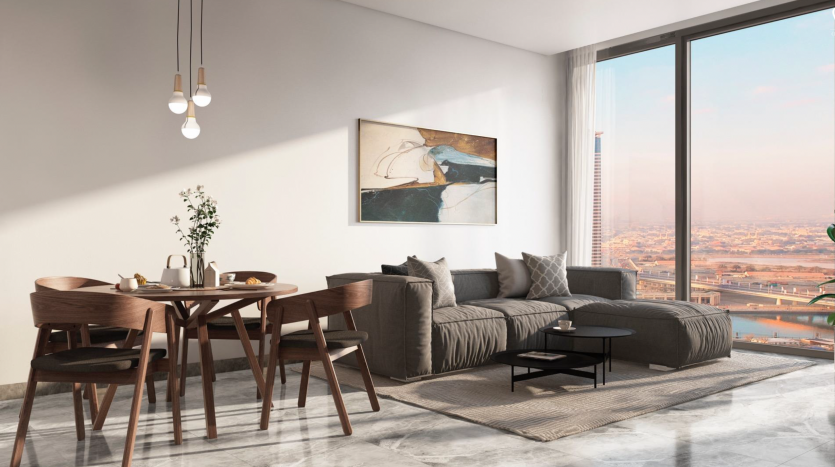 Un salon d&#039;appartement moderne et ensoleillé avec un canapé, une table à manger et de grandes fenêtres donnant sur le paysage urbain de la péninsule de Dubaï. La décoration élégante comprend une grande peinture abstraite et des plantes d&#039;intérieur.
