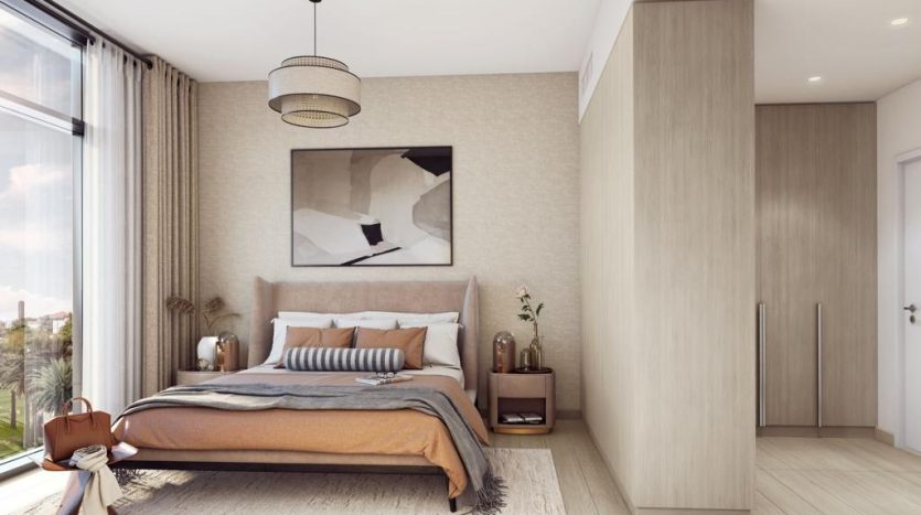 Une chambre moderne dans Harrington House comprenant un grand lit avec une literie neutre, des meubles en bois, une œuvre d&#039;art abstraite encadrée au-dessus du lit et une grande fenêtre laissant entrer beaucoup de lumière naturelle.