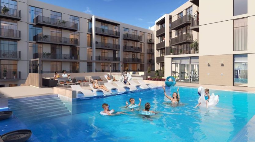 Une piscine extérieure animée du complexe d&#039;appartements Harrington House, où les gens profitent du soleil, nagent et flottent sur des jouets gonflables. Les bâtiments disposent de balcons donnant sur la piscine.