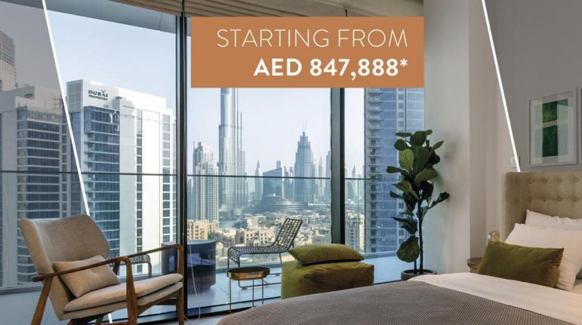 Un intérieur d&#039;appartement moderne comprenant une chambre avec un grand lit, une chaise et une fenêtre donnant sur les toits de la ville. La superposition de texte présente une offre de prix de départ pour la propriété Marquise Square Dubai.