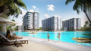 Роскошный курорт на берегу моря в районе 1 Дубая: люди отдыхают на песчаном пляже, другие катаются на паддлборде, на заднем плане - современные многоэтажные здания в окружении пальм.