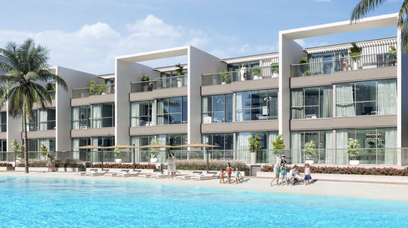 Des immeubles résidentiels modernes dotés de grands balcons surplombent un lagon bleu scintillant de Dubaï, entourés de palmiers et de personnes pratiquant diverses activités comme la natation et les bains de soleil.
