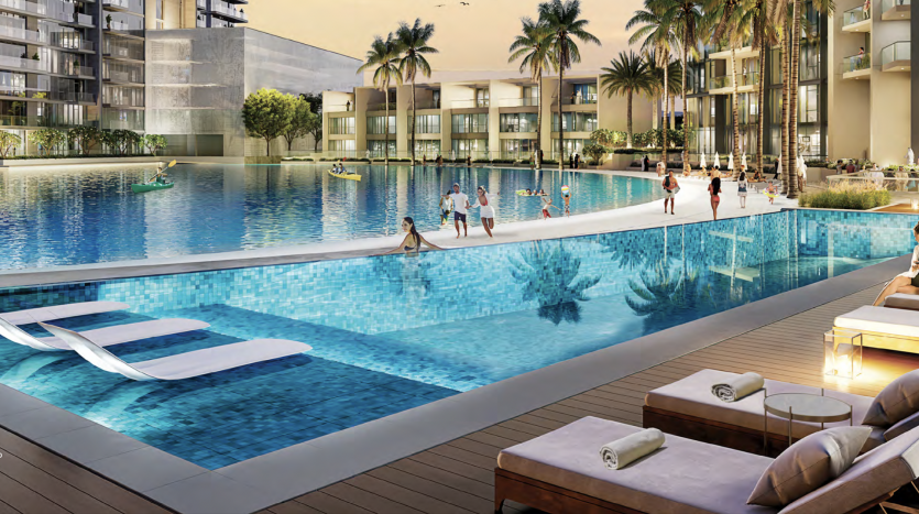 Espace luxueux au bord de la piscine dans un complexe moderne de Dubaï, doté d&#039;une vaste piscine, de chaises longues et de résidents profitant de diverses activités sous un coucher de soleil éclatant avec vue sur le lagon.