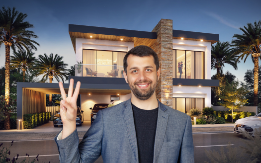 Un homme souriant avec une barbe, faisant un signe de paix, se tient devant une maison moderne à deux étages à Dubaï avec des intérieurs éclairés, des palmiers et une voiture garée à l'extérieur au crépuscule.