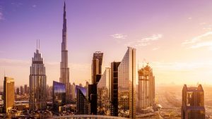 Une vue panoramique des meilleurs quartiers de Dubaï avec le Burj Khalifa au lever du soleil, avec des reflets dorés sur les bâtiments de verre modernes.
