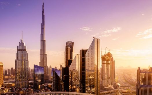 Une vue panoramique des meilleurs quartiers de Dubaï avec le Burj Khalifa au lever du soleil, avec des reflets dorés sur les bâtiments de verre modernes.