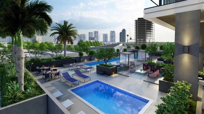 Un luxueux toit-terrasse avec piscine, mobilier moderne et verdure luxuriante à Catch Dubai, entouré de gratte-ciel en arrière-plan.