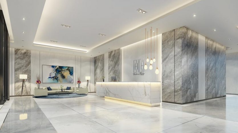 Un hall d'entrée moderne avec des murs en marbre, un bureau de réception élégant, des coins salons élégants, des lumières décoratives et des œuvres d'art contemporaines inspirées de l'esthétique de Catch Dubai.