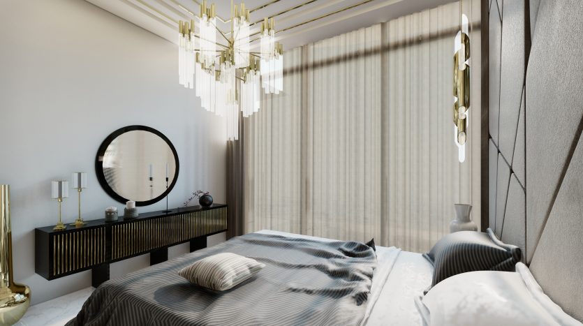 Une chambre moderne comprenant un grand lit avec une literie à rayures, un miroir rond au-dessus d&#039;une console sombre et élégante, des suspensions élégantes et un éclairage naturel doux filtré à travers des rideaux transparents à Samana Waves Dubai.
