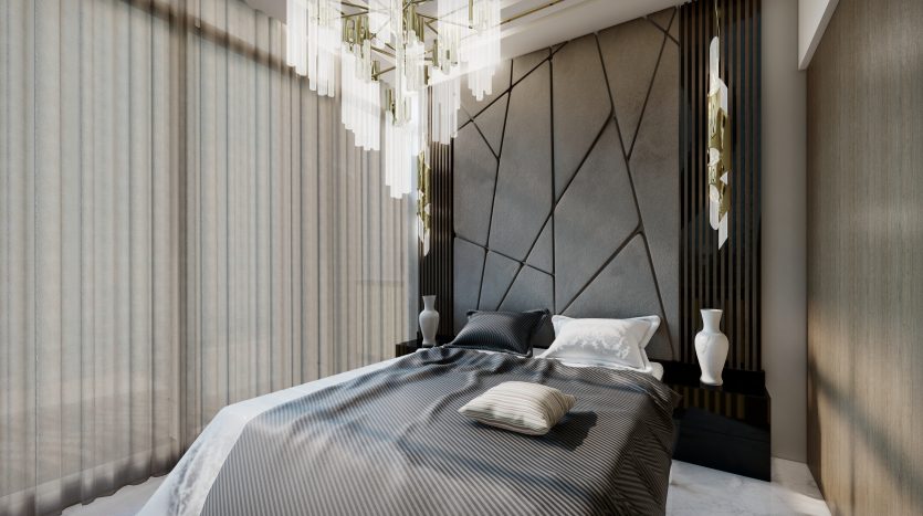 Chambre moderne du Samana Waves Dubai comprenant un grand lit avec une literie grise, une tête de lit à motifs géométriques et d&#039;élégantes suspensions. La douce lumière du jour filtre à travers des rideaux transparents.
