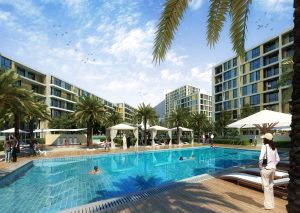 Une luxueuse piscine de style complexe entourée d'immeubles d'appartements modernes, de palmiers et de chaises longues, où les gens profitent de diverses activités sous un ciel bleu clair. Cette scène est typique d'une villa haut de gamme