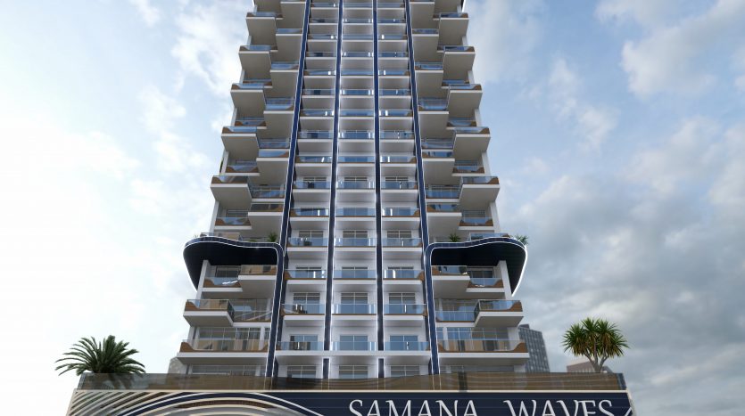 Immeuble d&#039;appartements moderne avec un motif ondulé distinctif sur la façade, nommé &quot;Samana Waves Dubai&quot;, sous un ciel partiellement nuageux.