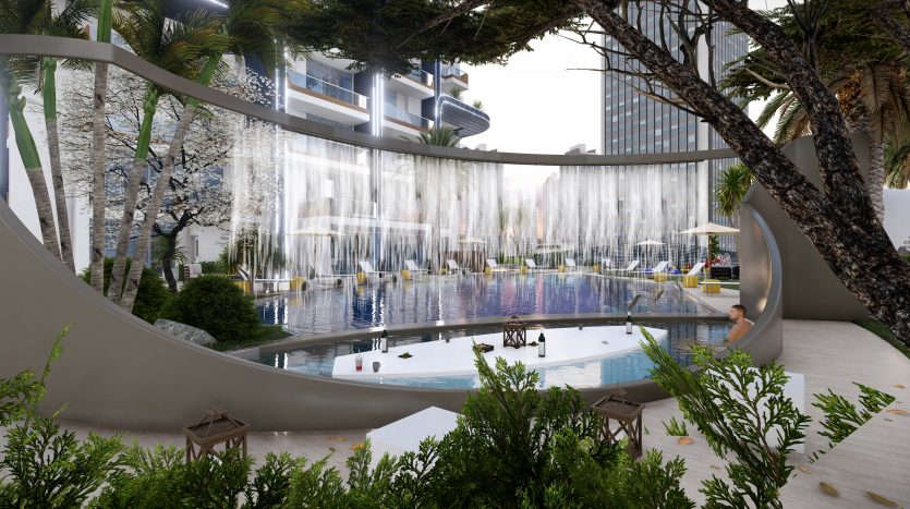 Une piscine extérieure luxueuse avec des jeux d&#039;eau élégants et une végétation luxuriante, entourée des immeubles modernes de grande hauteur du Samana Waves Dubai, sous un ciel dégagé. Le bord de la piscine est équipé de chaises longues et animé