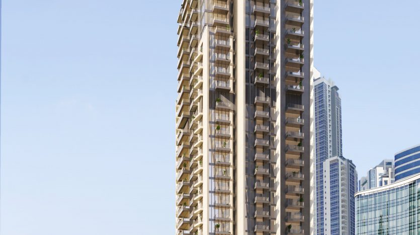 Un immeuble résidentiel moderne de grande hauteur à Dubaï avec des sommets triangulaires distinctifs, entouré de palmiers et d&#039;autres gratte-ciel sous un ciel bleu clair.