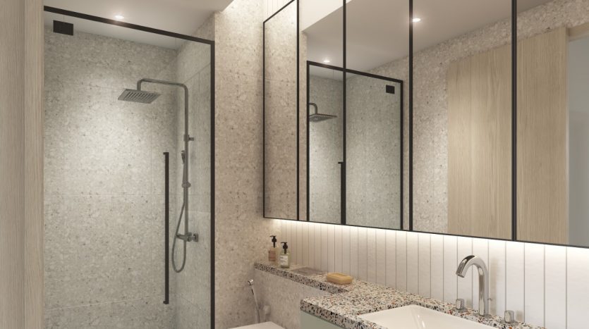 Salle de bain moderne comprenant un grand miroir, un comptoir en terrazzo, deux lavabos et une spacieuse douche à l&#039;italienne avec portes vitrées. L&#039;éclairage doux et les accents de bois de cette villa de Dubaï créent une ambiance chaleureuse.