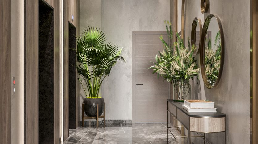 Un hall d&#039;entrée moderne et élégant avec des sols en marbre brillant, des murs gris, des accents dorés et des plantes vertes luxuriantes. Il y a un ascenseur sur la gauche et un coin salon élégant avec des miroirs circulaires sur la droite.