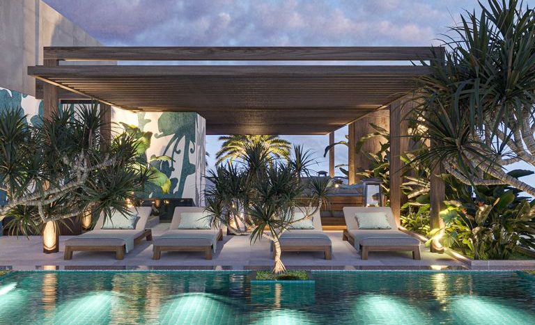 Coin salon luxueux au bord de la piscine au crépuscule dans une villa de Dubaï, doté d&#039;une piscine bleue illuminée entourée de plantes vertes luxuriantes, avec des sièges modernes et élégants sous un auvent en bois.