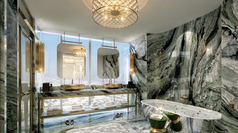 Une salle de bains luxueuse dans une villa à Dubaï avec des murs et un sol en marbre, une vasque en or et en verre, des vasques doubles, des miroirs ornés et un tapis blanc moelleux. La lumière du soleil traverse un