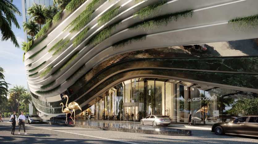 Un bâtiment futuriste avec des terrasses ondulantes ornées de verdure, idéal pour investir à Dubaï, se trouve à côté d'une rue avec des gens, des voitures et un grand flamant rose sculpté. Vibreur