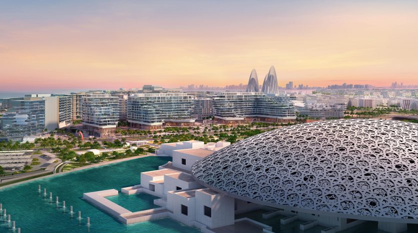 Vue aérienne d&#039;un paysage urbain moderne au bord de l&#039;eau au coucher du soleil à Dubaï, présentant une architecture distinctive comprenant un bâtiment en forme de dôme et des gratte-ciel futuristes en arrière-plan.