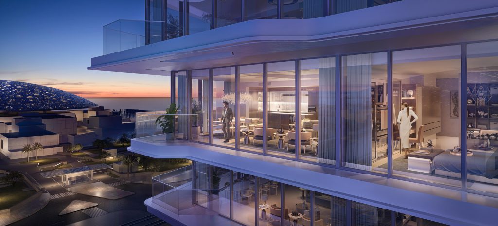 Une luxueuse façade d&#039;appartement moderne au crépuscule avec de vastes murs de verre, révélant des espaces intérieurs élégants. Une femme se tient à l’intérieur, près du balcon, surplombant les toits de Dubaï.