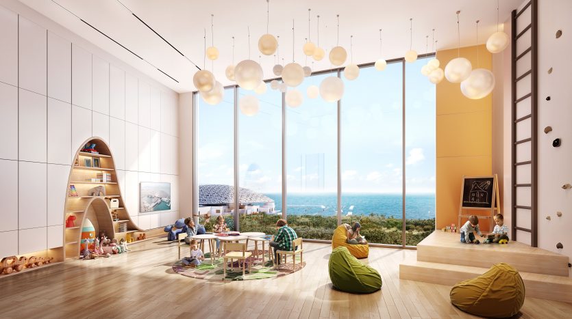 Villa spacieuse et ensoleillée à Dubaï avec de grandes fenêtres donnant sur la mer, meublée d&#039;une aire de jeux, de poufs et d&#039;une table à manger, où des personnes de différents âges se détendent et interagissent.