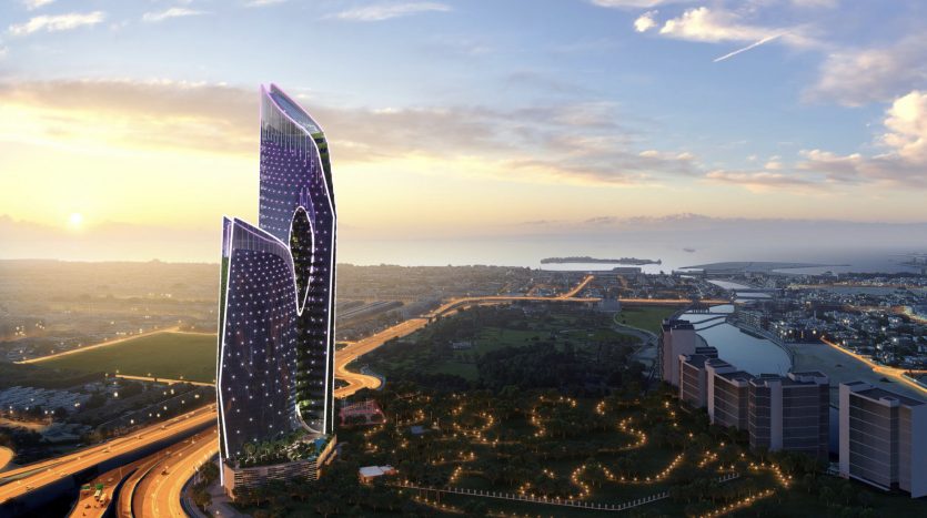 Un rendu numérique d&#039;un gratte-ciel futuriste et illuminé avec des motifs incurvés au coucher du soleil, surplombant un paysage urbain avec un rivage lointain et un ciel nuageux à Dubaï.