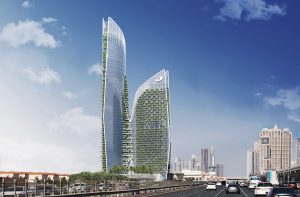 Deux gratte-ciel futuristes avec de la verdure sur leurs façades, l'un courbe et l'autre droit, se dressent sur un ciel bleu clair dans une ville animée de Dubaï avec des routes très fréquentées en contrebas.
